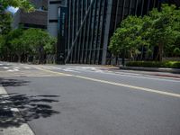 a city intersection with many buildings and trees on both sides of the road and on the sidewalk