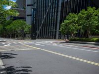 a city intersection with many buildings and trees on both sides of the road and on the sidewalk