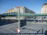 the cars on the street are stopped at the intersection with a pedestrian and a sign