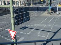 the cars on the street are stopped at the intersection with a pedestrian and a sign