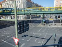 the cars on the street are stopped at the intersection with a pedestrian and a sign