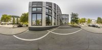 a view from the street through the fish eye lens of an intersection in the middle of a city