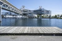 a boat dock next to a bridge over water in front of a building with a big glass windows