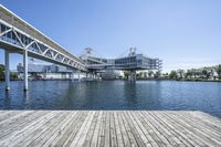 a boat dock next to a bridge over water in front of a building with a big glass windows