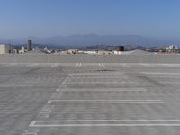 a parking lot with mountains in the background and blue sky overhead, viewed from above