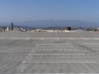 a parking lot with mountains in the background and blue sky overhead, viewed from above