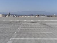 a parking lot with mountains in the background and blue sky overhead, viewed from above