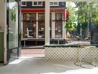 a white tiled floor near glass doors and windows with people sitting on the sidewalk in front