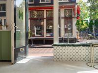 a white tiled floor near glass doors and windows with people sitting on the sidewalk in front
