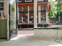 a white tiled floor near glass doors and windows with people sitting on the sidewalk in front