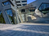 the buildings are made from concrete and glass on a clear day that is reflecting the sky