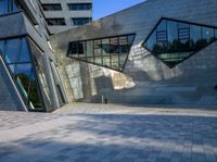 the buildings are made from concrete and glass on a clear day that is reflecting the sky