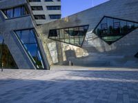 the buildings are made from concrete and glass on a clear day that is reflecting the sky