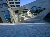 the buildings are made from concrete and glass on a clear day that is reflecting the sky