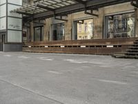 an empty building with signs on the street and people on bikes in traffic passing by