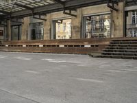 an empty building with signs on the street and people on bikes in traffic passing by