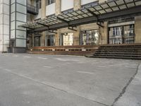 an empty building with signs on the street and people on bikes in traffic passing by