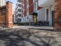 this is an image of the entrance of a building with bicycles parked on it's sidewalks