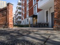 this is an image of the entrance of a building with bicycles parked on it's sidewalks