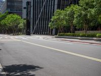 there is an empty street in the middle of a city area with tall buildings on either side