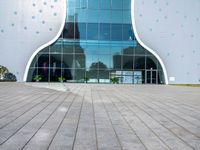 the entrance to an office building in a city with polka dot walls and a concrete walkway