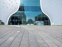 the entrance to an office building in a city with polka dot walls and a concrete walkway