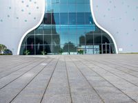 the entrance to an office building in a city with polka dot walls and a concrete walkway