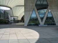 a square paved area has three arches and is set high on one of several tall buildings