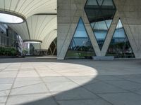 a square paved area has three arches and is set high on one of several tall buildings