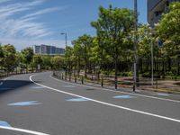 empty road with white lines on the streets of city area against cloudy blue sky on a sunny day