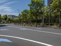 empty road with white lines on the streets of city area against cloudy blue sky on a sunny day