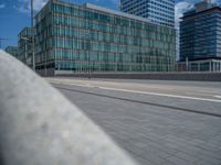 buildings and road in urban area, with cars on the side and pedestrians walking across the road