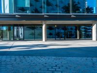 a building with glass windows has a sign on it that says, the front door