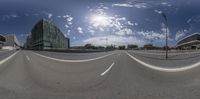 360 - view photograph of a city intersection with a cloudy sky above and below the buildings