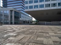 an empty courtyard in front of large building with many windows and wooden decking area