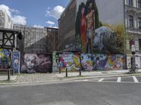 the street in front of the graffiti covered building is empty and empty, but has two rows