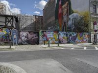 the street in front of the graffiti covered building is empty and empty, but has two rows