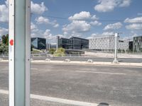 a street is empty in front of buildings with a bridge crossing it to the right