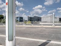 a street is empty in front of buildings with a bridge crossing it to the right