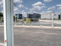 a street is empty in front of buildings with a bridge crossing it to the right