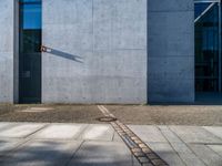 a gray wall with a small line of street lights on it's sides and in the middle of some concrete