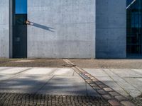 a gray wall with a small line of street lights on it's sides and in the middle of some concrete