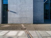 a gray wall with a small line of street lights on it's sides and in the middle of some concrete