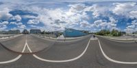 the reflection of a road in a fish eye lens, with several buildings in the background