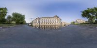 a fish eye photo of a large building and trees in the city street from the front