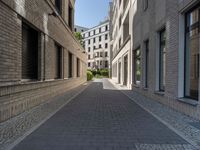 a narrow alley that contains some apartment buildings on each side of the street, along with another building on the other side, a concrete box