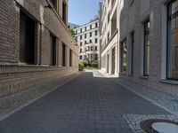 a narrow alley that contains some apartment buildings on each side of the street, along with another building on the other side, a concrete box