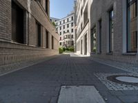 a narrow alley that contains some apartment buildings on each side of the street, along with another building on the other side, a concrete box