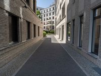 a narrow alley that contains some apartment buildings on each side of the street, along with another building on the other side, a concrete box