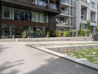 a woman with her bike is walking on the sidewalk by a building or condo complex